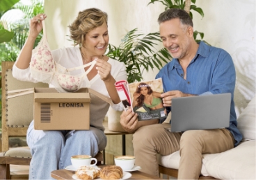 Pareja revisando catálogo y productos Leonisa